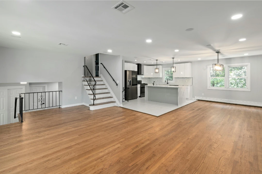 Modern open-concept living space with hardwood floors and a new kitchen, fully renovated by BUILDUP Remodeling & Construction.