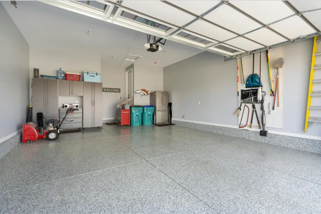 Clean, spacious garage interior with a freshly installed garage door, workbench, and functional storage space.